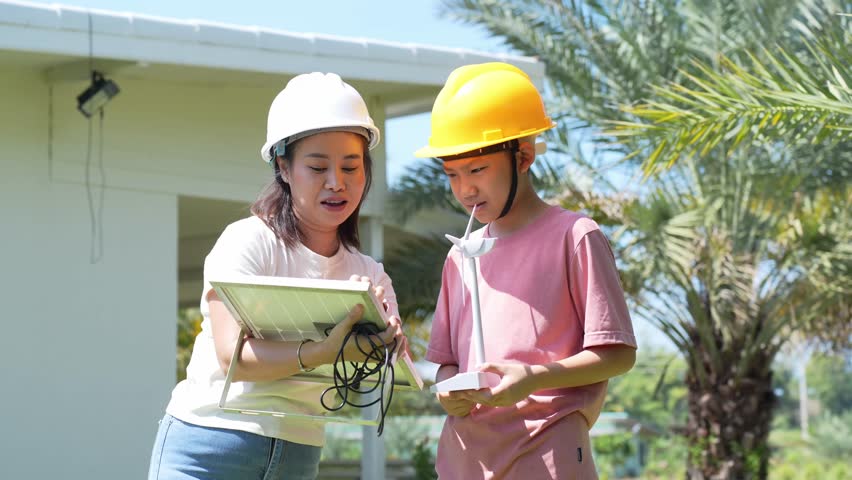 Female Engineer explains clean energy to children with wind turbine and solar panel models. Great for topics like STEM, environment, and energy awareness in education.