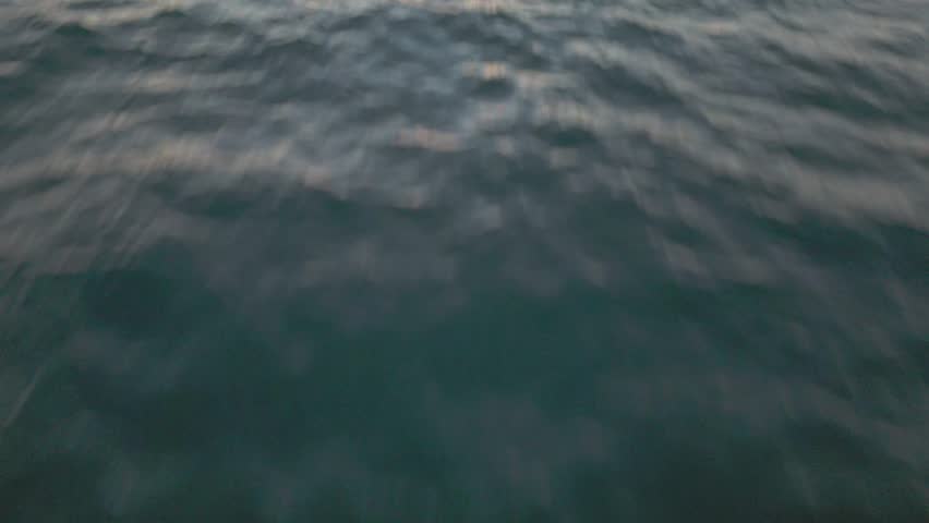 Low-flying aerial reveal shot of San Gabriel River jetty at sunset, Seal Beach, California