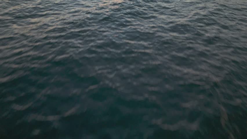 Low-flying aerial reveal shot of San Gabriel River jetty at sunset, Seal Beach, California