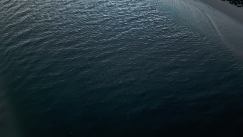 Aerial reveal shot of boats sailing through the Alamitos Bay Inlet at sunset, Seal Beach, California