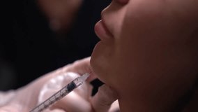 Beautician doctor makes botulinum toxin injection in the chin of young beautiful woman. Close up 4k shot - Powered by Shutterstock - Get 15% off with code: PIKWIZARD15