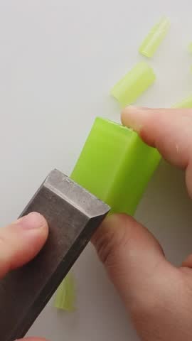 Close-up. Cutting light green soap, creating graceful curls. The precise movement of the cutting tool allows you to create swirling patterns, creating visual enjoyment.ASMR