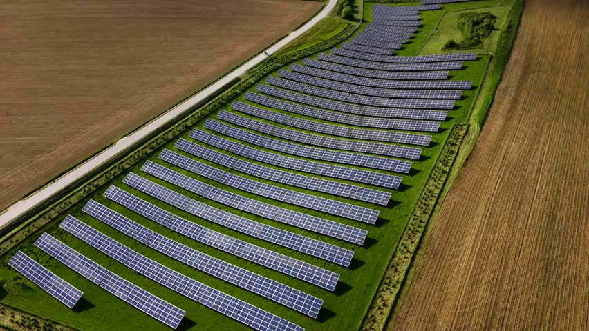 Top-down aerial view of two bikers cycling through German countryside, flanked by golden crops and solar panels. Symbol of clean transport, renewable energy, and eco-conscious lifestyle 