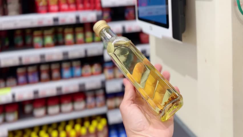 choosing olive oil, sauce, vinegar at the grocery store