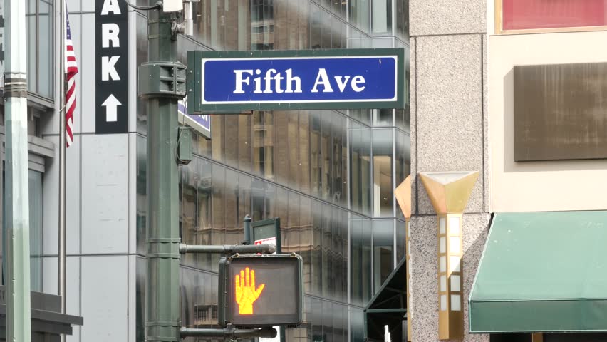Fifth avenue, 5 ave road sign, Manhattan midtown architecture, New York City 5th av street corner. Traffic crossroad signage, USA. Parking garage and american flag.