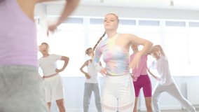 Group of boys and girls with teacher doing warm-up exercises before dancing in studio - Powered by Shutterstock - Get 15% off with code: PIKWIZARD15