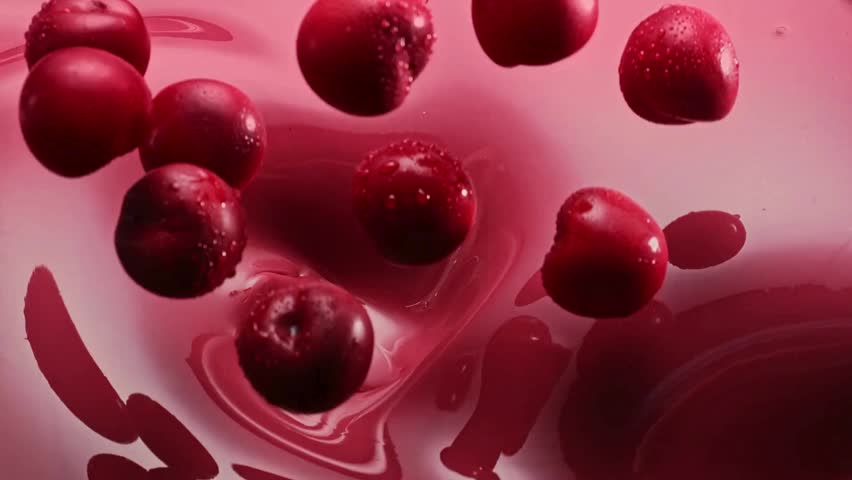 Fresh cherries splash into pink cherry ice cream.