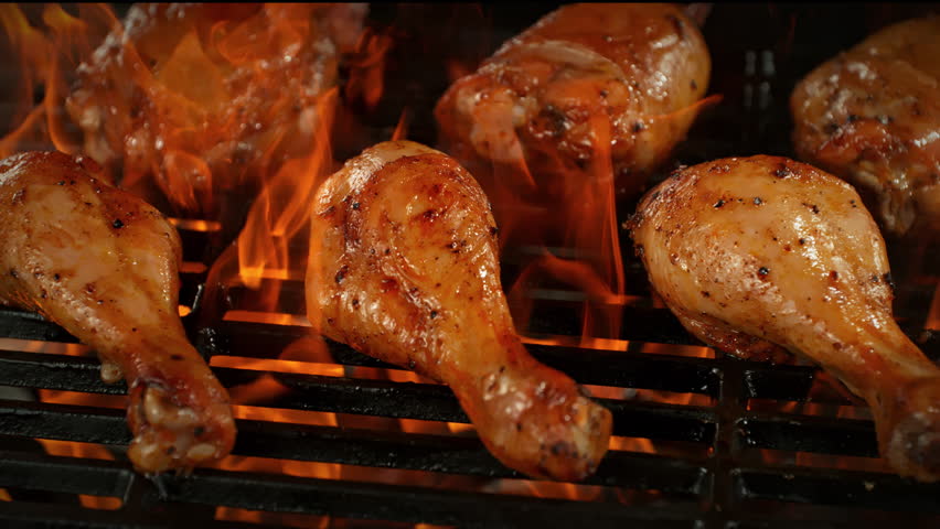 Super Slow Motion Shot of Chicken Drumsticks on Fired Up Grill with Camera Motion at 1000fps.