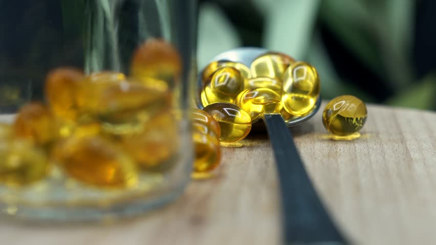  Golden Omega-3 Fish Oil Capsules: Close-up of Shiny Softgel Dietary Supplements. Health, Wellness, and Nutrition for Pharmaceutical and Medical Content.