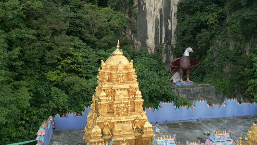 Aerial view of golden Hindu temple roof with monkeys at Batu Caves, Malaysia. Ideal for travel, culture, wildlife, and Southeast Asian spirituality themes.