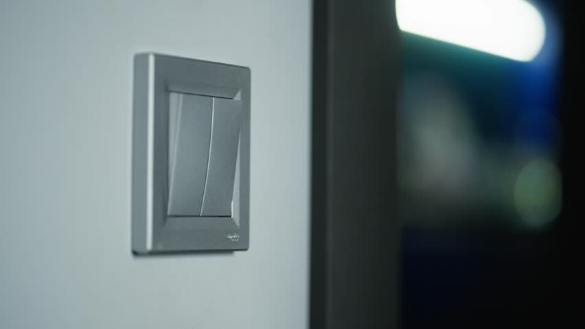 Close-up of a woman's hand turning on the light with a switch. High quality 4k footage