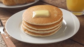Maple syrup being poured on stack of steaming buttered pancakes. Stack of Pancakes with Melting Butter. adds maple syrup to pancakes in home kitchen. - Powered by Shutterstock - Get 15% off with code: PIKWIZARD15