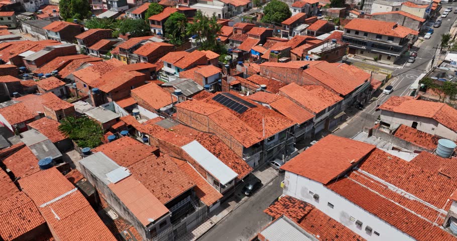 Dense favela with red tiled rooftops and narrow streets in Sao Luis (São Luís), Brazil. Close up aerial, dolly in