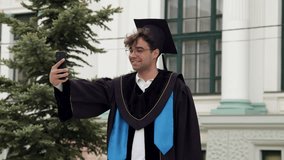 Male student takes selfie smiling in gown near tall building - Powered by Shutterstock - Get 15% off with code: PIKWIZARD15