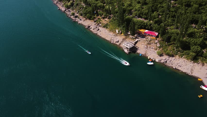 Boats in Upper Kachura Lake surrounded by rugged mountains and lush valleys in northern Pakistan