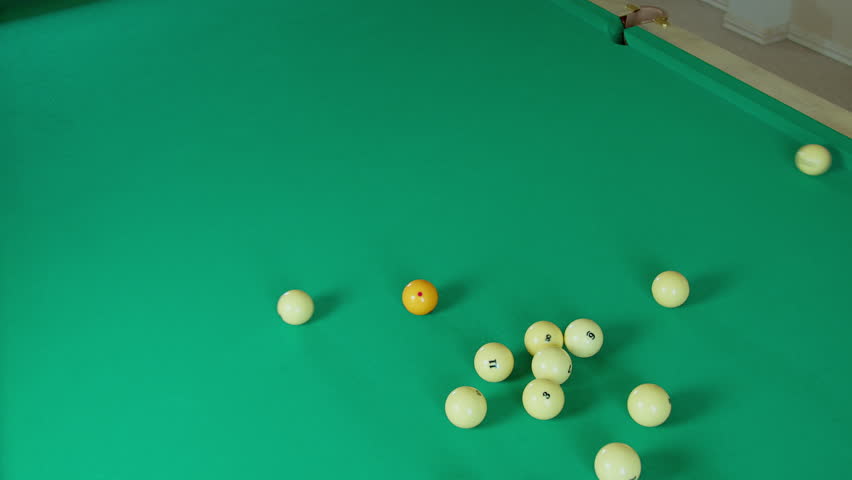 A player breaks a pyramid of billiard balls with a ball, a game of Russian billiards