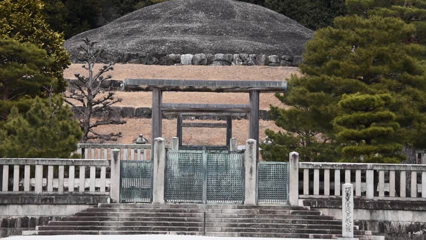 The mausoleum of Emperor Kōmei, father of Emperor Meiji, stands solemnly in Kyoto, Japan, marked by torii gates, symmetrical stonework, and a forested burial mound.