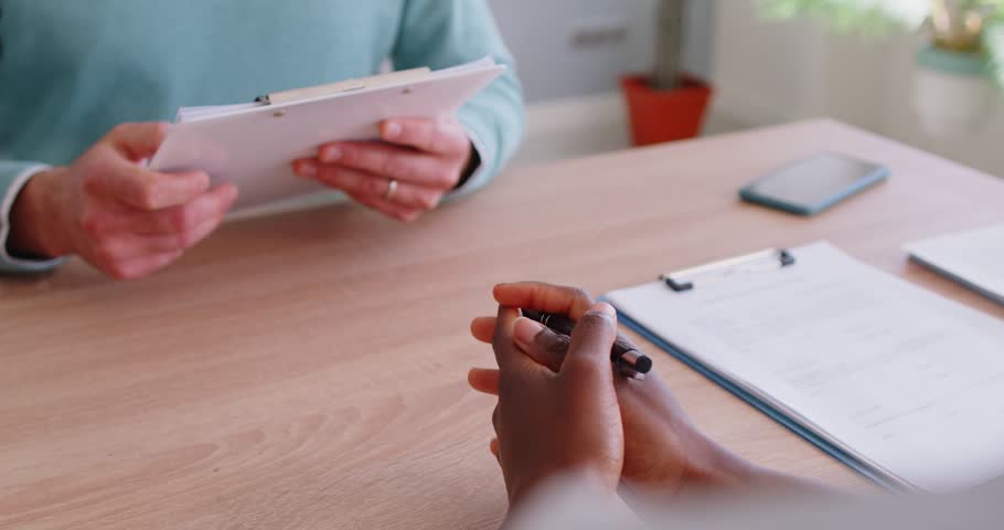 Close up of female HR manager greeting male candidate with handshake, receiving resume from job applicant during interview. Human resources recruitment, hiring process and career opportunity concept.