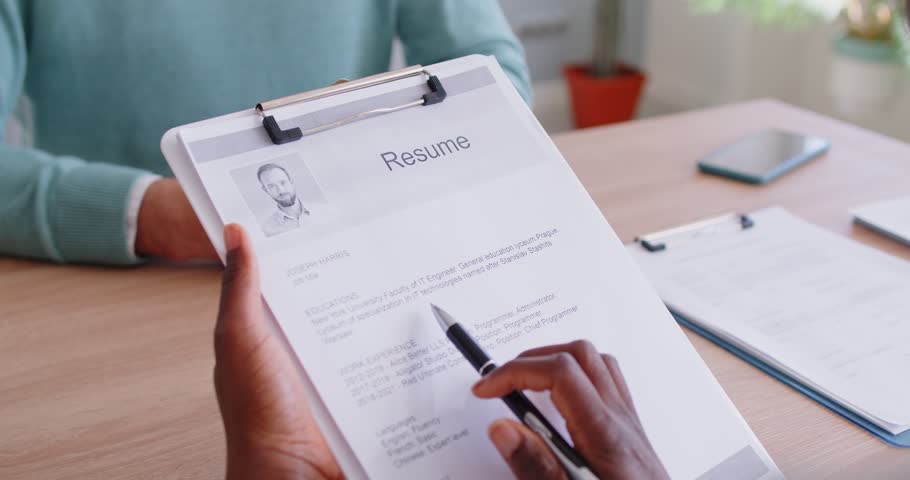 Close up of female HR manager greeting male candidate with handshake, receiving resume from job applicant during interview. Human resources recruitment, hiring process and career opportunity concept.