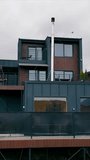 Modern Hillside Home with Balconies and Patio Space. A contemporary hillside home featuring a multi-level design with wooden and metal accents, spacious balconies, a patio area, and a rooftop lounge. - Powered by Shutterstock - Get 15% off with code: PIKWIZARD15