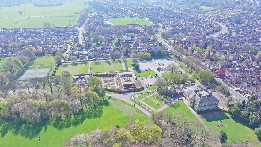 Spring aerial of green open park bordered by trees and curved trail system, Clifton Park Rotherham UK
