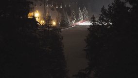 Cable cars hang above frost-covered trees near a mountain lodge glowing in soft winter lighting. Snow groomers move along the ski slope. - Powered by Shutterstock - Get 15% off with code: PIKWIZARD15