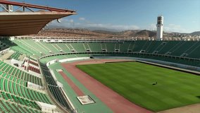 Aerial view inside empty Stade Adrar, showing green football pitch and running track, Agadir, Morocco - Powered by Shutterstock - Get 15% off with code: PIKWIZARD15