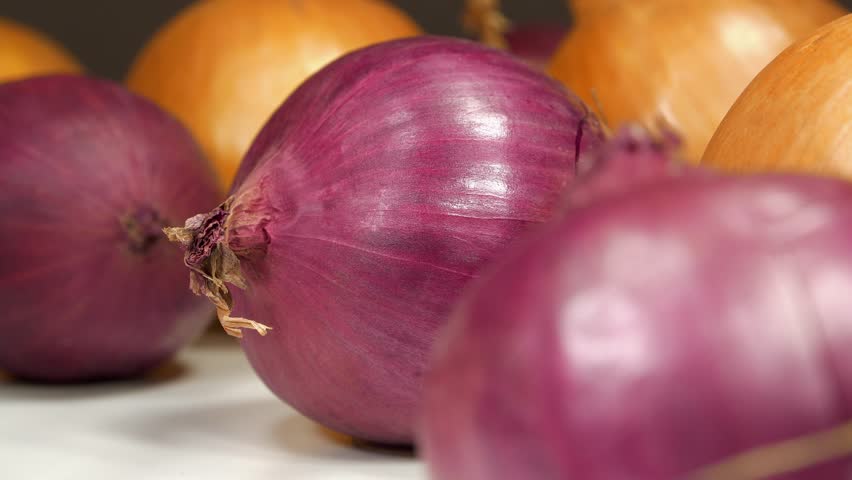 Bulb onion and red onion, which is also called purple onion. Onion - very healthy product with many beneficial properties. Rotates on black background, close-up shot studio video