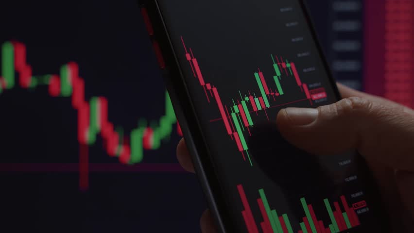Close-up of hand interacting with stock market candlestick chart on a smartphone, indicating trading, investing, or financial analysis.  - Powered by Shutterstock - Get 15% off with code: PIKWIZARD15