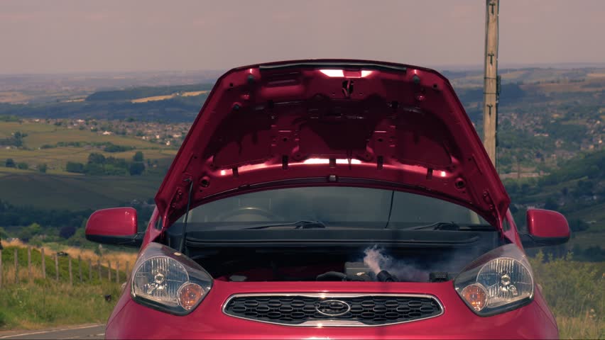 Broken down car with smoke coming out of engine medium zoom shot selective focus