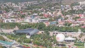Rike Park from above. Modern urban park in the old town of Tbilisi aerial timelapse. Green trees and lawn at relaxing area in the city. The Bridge of Peace and concert hall. Georgia - Powered by Shutterstock - Get 15% off with code: PIKWIZARD15