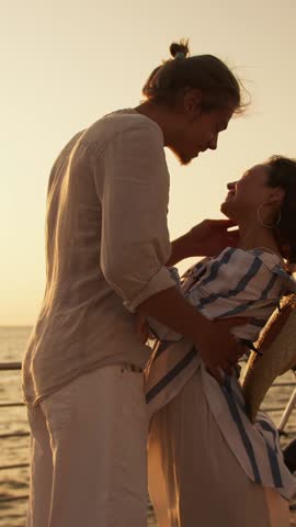 A young couple embraces on a serene beach at sunset, basking in the warm glow and sharing tender smiles as they celebrate their love and connection