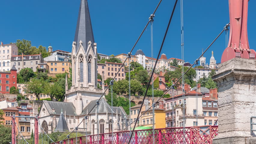 Timelapse hyperlapse of Saint George Church, Quais de Saone, and Fourviere Basilica from a footbridge in Vieux Lyon, France, showcasing historic architecture, reflections and a scenic river view