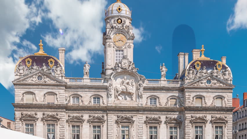 Hyperlapse of Hotel de Ville de Lyon, the historic city hall of Lyon, France. People stroll near the fountain on the square timelapse. A baroque and classical architectural marvel under a blue sky