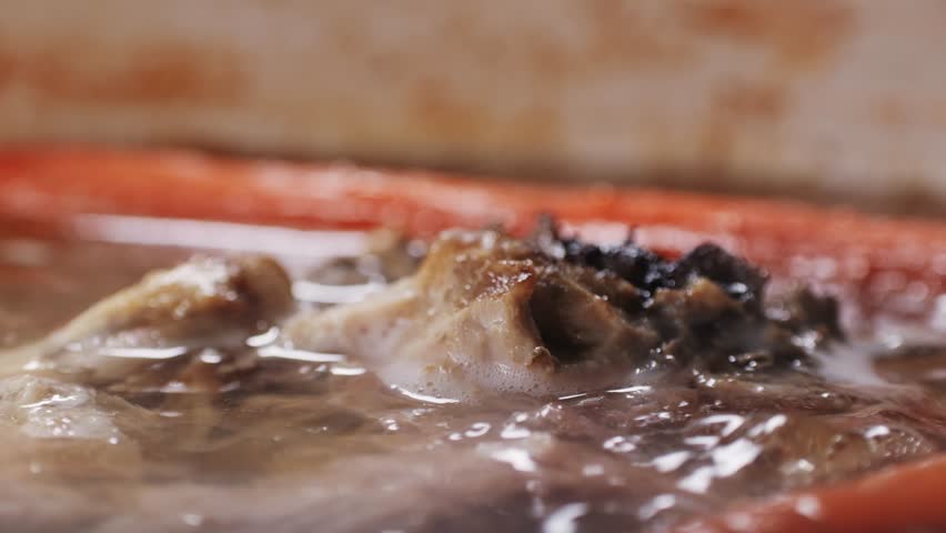 Cooking pot with bone broth meat pork and beef, aspic north food. Vegetables cooking ingredients and spices on kitchen table. 
