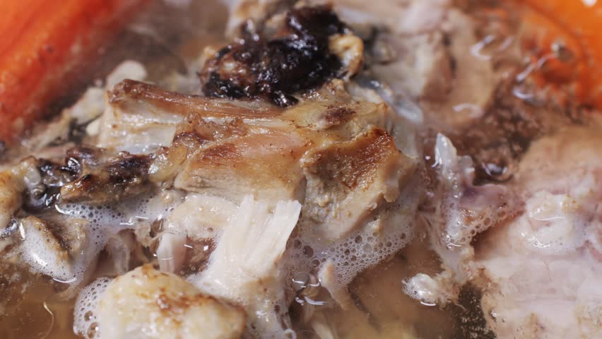 Cooking pot with bone broth meat pork and beef, aspic north food. Vegetables cooking ingredients and spices on kitchen table. 