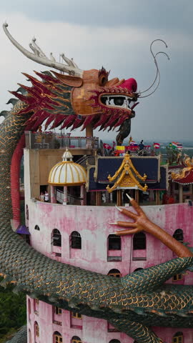 Wat Samphran a Buddhist temple near Bangkok features a striking pink cylindrical building with a giant dragon
