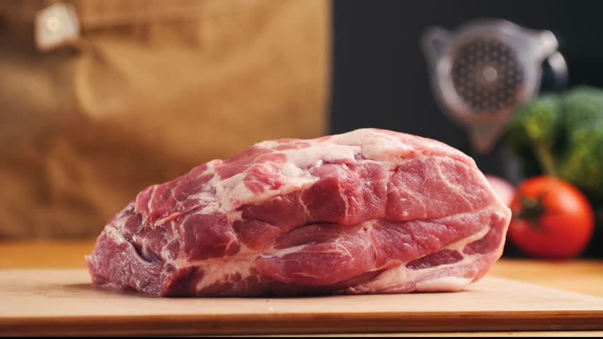 Man cut meat steak, beef pork neck cooking, Cook Butcher. The chef cuts the meat for cooking. Neck carbonate with vegetables cutting on ktchen for bbq grill, marinade. 