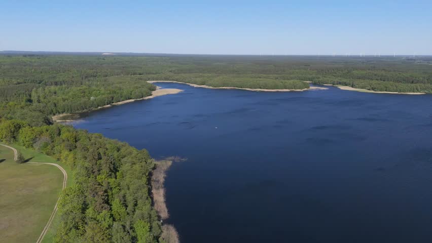 Clear lake surrounded by forests. Beautiful Polish landscape. Aerial view.
