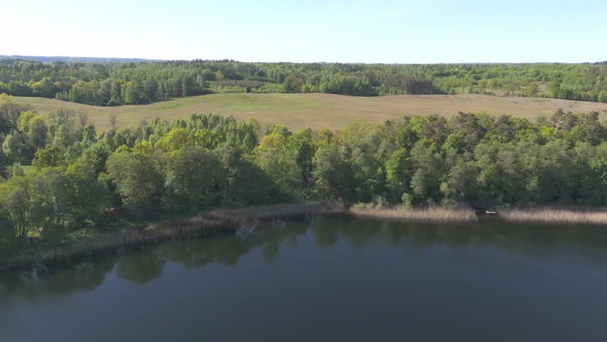 Clear lake surrounded by forests. Beautiful Polish landscape. Aerial view.
