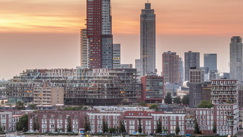 Aerial day to night transition timelapse of Katendrecht peninsula and Maashaven harbour in Rotterdam, The Netherlands. City skyline modern skyscrapers and traditional Dutch waterfront houses