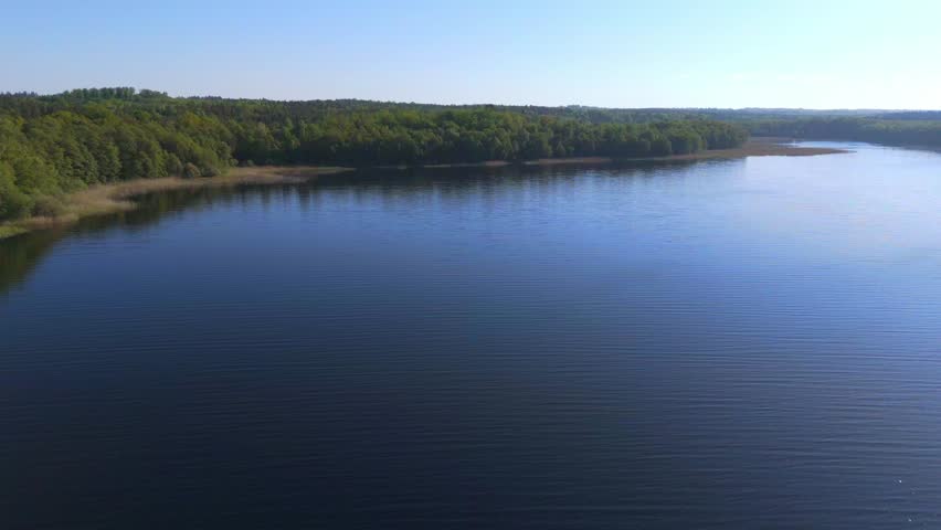 Clear lake surrounded by forests. Beautiful Polish landscape. Aerial view.
