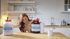 A young, athletic Asian woman in stylish sportswear prepares a nutritious protein shake in her modern kitchen while live-streaming a health-focused video tutorial. With a cheerful smile - Powered by Shutterstock - Get 15% off with code: PIKWIZARD15