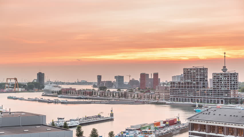 Panoramic aerial day to night transition timelapse of Katendrecht peninsula and Maashaven harbour in Rotterdam, The Netherlands. City skyline modern skyscrapers and traditional Dutch waterfront houses