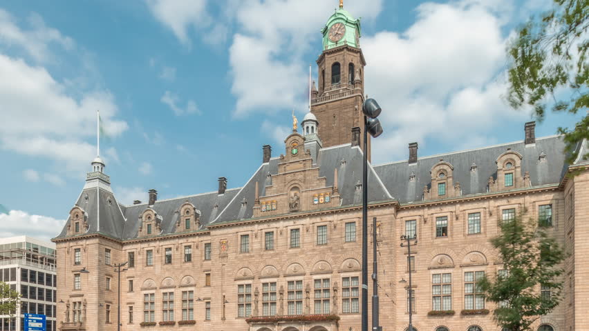 Hyperlapse of Rotterdam City Hall (Stadhuis van Rotterdam) at Coolsingel. One of the few historic buildings in the city center timelapse. Traffic and people on the street, cloudy blue sky. Netherlands