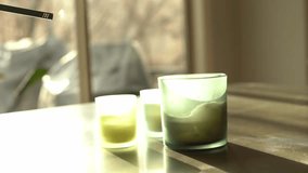 Hand lighting a candle in green frosted glass container with long lighter low shallow depth of field - Powered by Shutterstock - Get 15% off with code: PIKWIZARD15