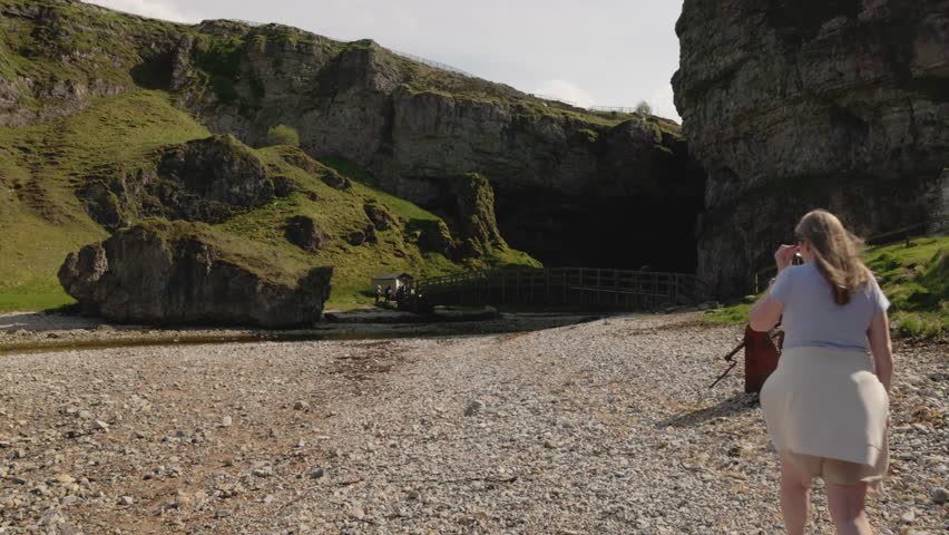 female tourists walking along the beach heading towards Smoo Cave to cross the bridge