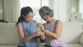 Young adult child give gift AI smart watch IOT app to mature middle age old mum. Love health care older mom asia elder people sit at home sofa happy family wear wrist trace help protect aging life. - Powered by Shutterstock - Get 15% off with code: PIKWIZARD15