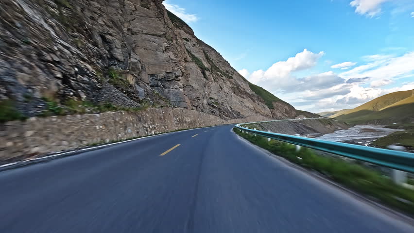 Driving a car through winding mountain road. Road trip.