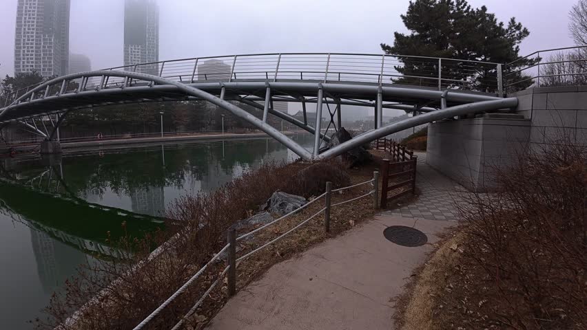 Walking Towards Bridge On Misty Morning At Songdo Central Park In Incheon, South Korea. POV shot